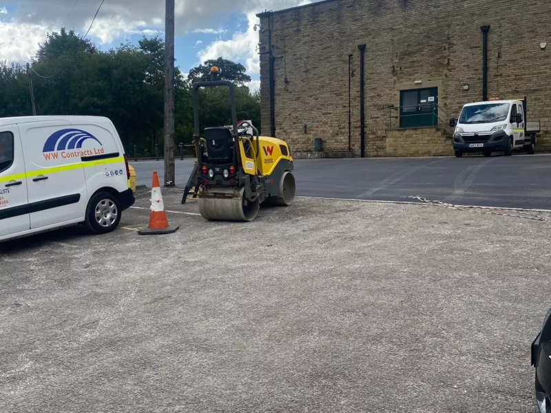 A newly paved tarmac road connecting to a car park