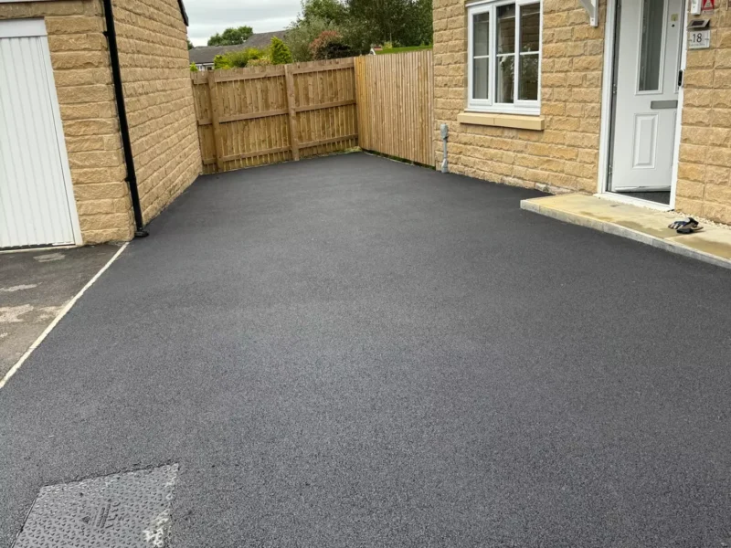 Fresh tarmac drive next to a new build home