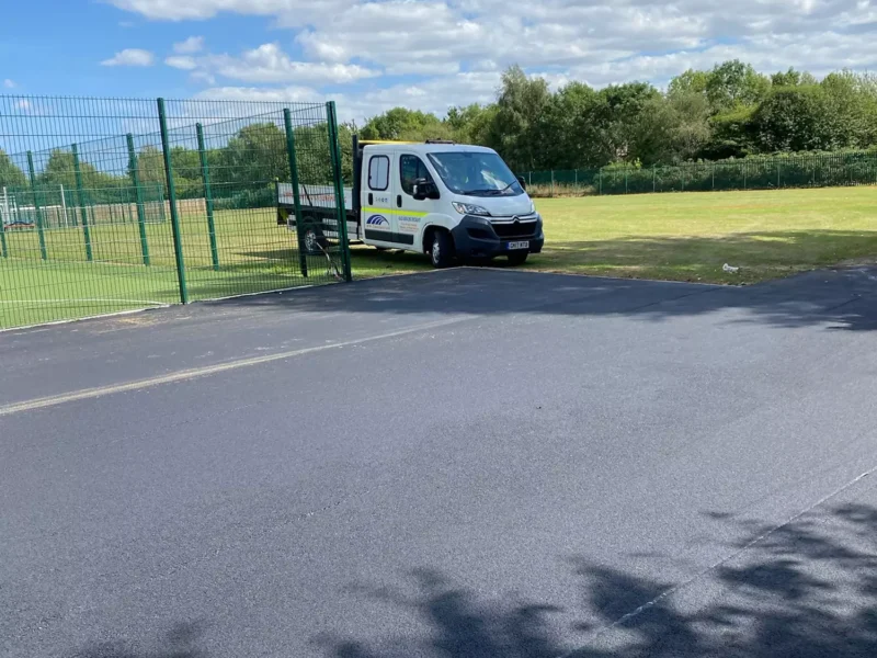 Tarmac carpark in front of a large grass area