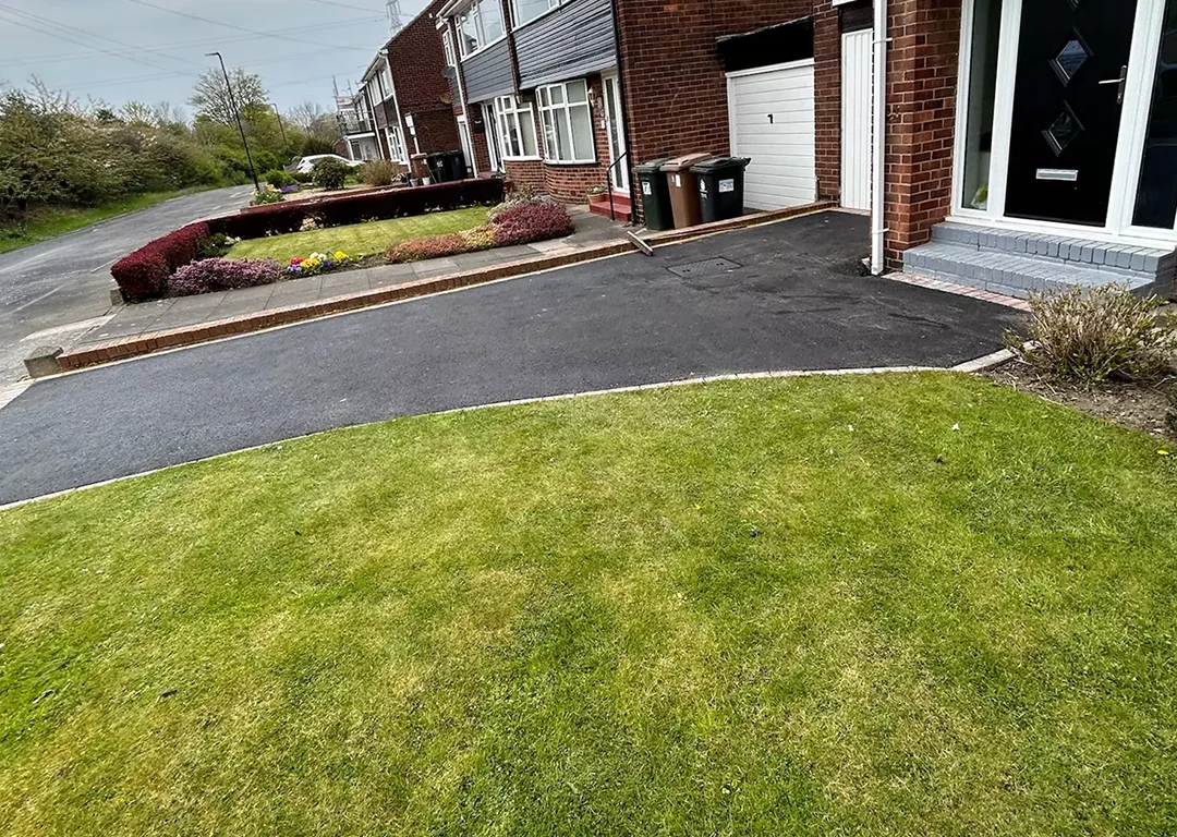 A newly installed tarmac driveway leading up to a residential home
